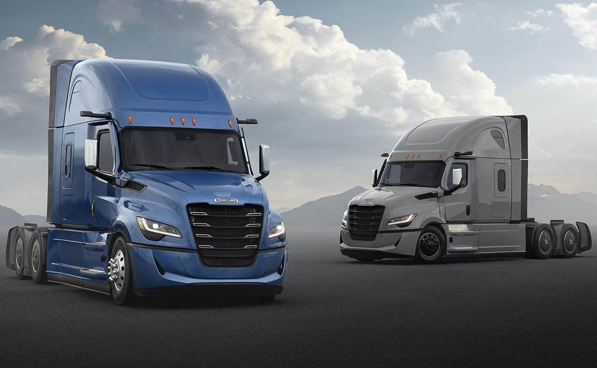 Two Freightliner Cascadia sleeper tractors, one blue and one silver, under a dramatic sky